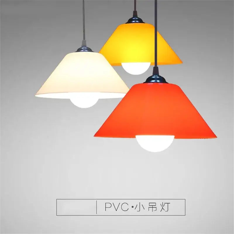 Modern amber glass and iron finish pendant light featuring three colorful pvc plastic shades in yellow orange and cream