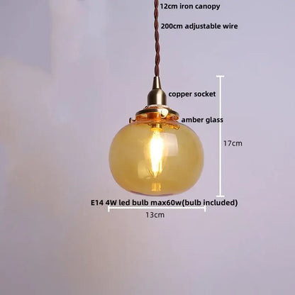 Modern amber glass ball led pendant light with warm amber glass, copper socket, and braided wire suspension for dining room