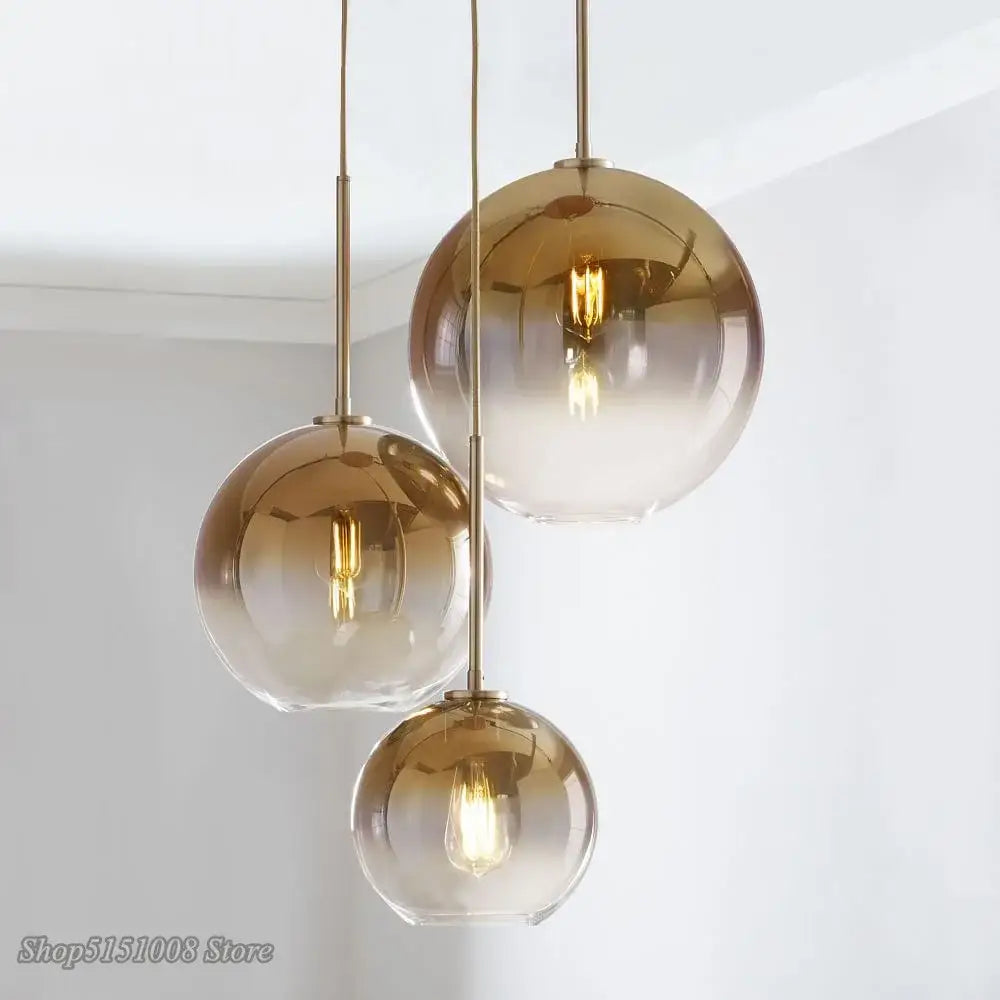 Three amber gradient glass ball led pendant lights with brass fixtures ideal for modern kitchen decorbites pendant light