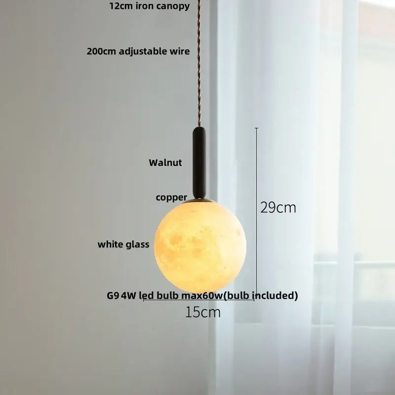 A warm amber glass led pendant light with a white glass globe and black walnut finish copper fixture for dining room