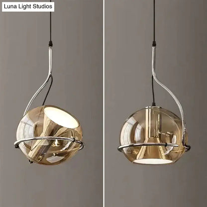 Modern amber glass pendant light with smoked glass globe and chrome metal frame for kitchen lighting