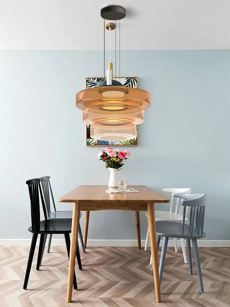 Modern amber glass plate ceiling pendant light with warm amber rings and black mount for dining room use