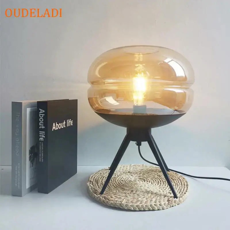Modern amber glass table lamp with black tripod base featuring exposed bulb for stylish bedroom decorbites glass table lamp