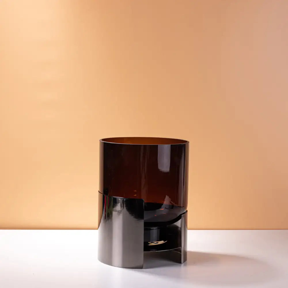 A sleek modern amber glass vase with a metallic silver base and geometric design decorbites amber glass decor