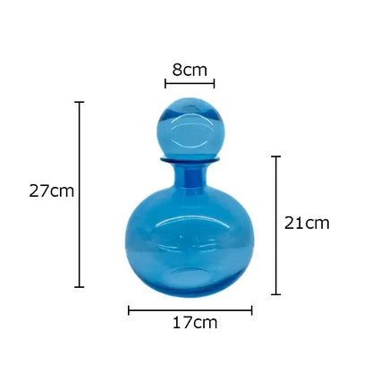 A translucent blue glass decanter with rounded body and spherical stopper in the modern amber glass vase trio decorbites amber glass