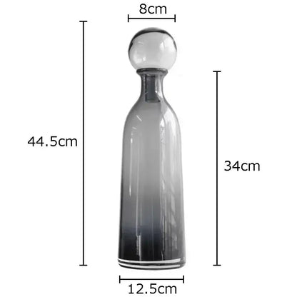 A sleek decorbites amber glass vase trio featuring gradient glass decanters with spherical stoppers for modern decor