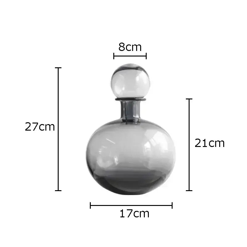 A sleek gray glass decanter with a rounded body and clear stopper from decorbites amber glass vase trio collection