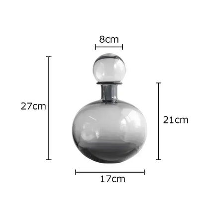 A sleek gray glass decanter with a rounded body and clear stopper from decorbites amber glass vase trio collection