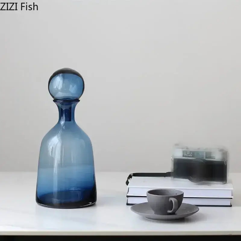 A sleek gradient blue glass decanter with rounded stopper from the modern amber glass vase trio by decorbites amber glass