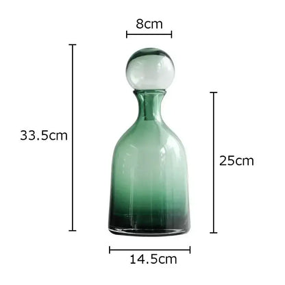 A tall slender decorbites amber glass decanter with gradient green tint and clear spherical stopper for living room hydroponics
