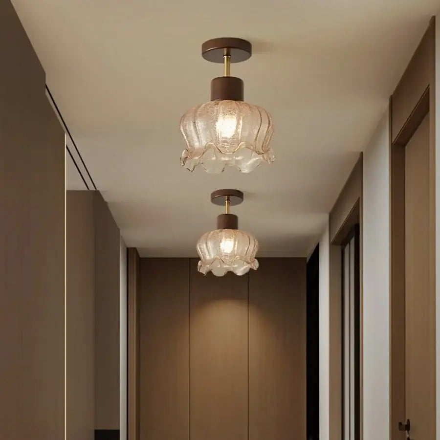 Two elegant translucent decorbites amber glass wood ceiling lights with fluted design hang in a living room hallway