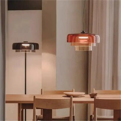 Modern amber layered glass pendant light with warm translucent rings suspended from black cord for dining room decorbites levels colorful glass