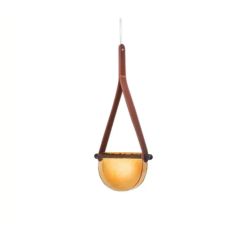 A modern amber pendant lamp with a warm glass bowl suspended by leather straps decorbites handmade glass pendant