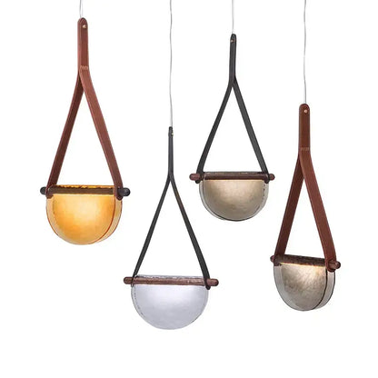 Three hanging pendant lamps with semi-spherical amber glass shades suspended by brown and black leather straps decorbites handmade glass