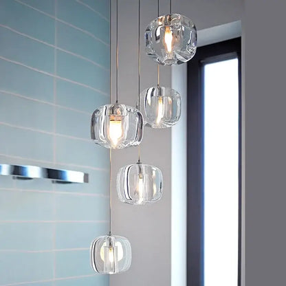 Modern amber and smoky grey crystal staircase chandelier with clear faceted glass pendant lights and warm glowing bulbs