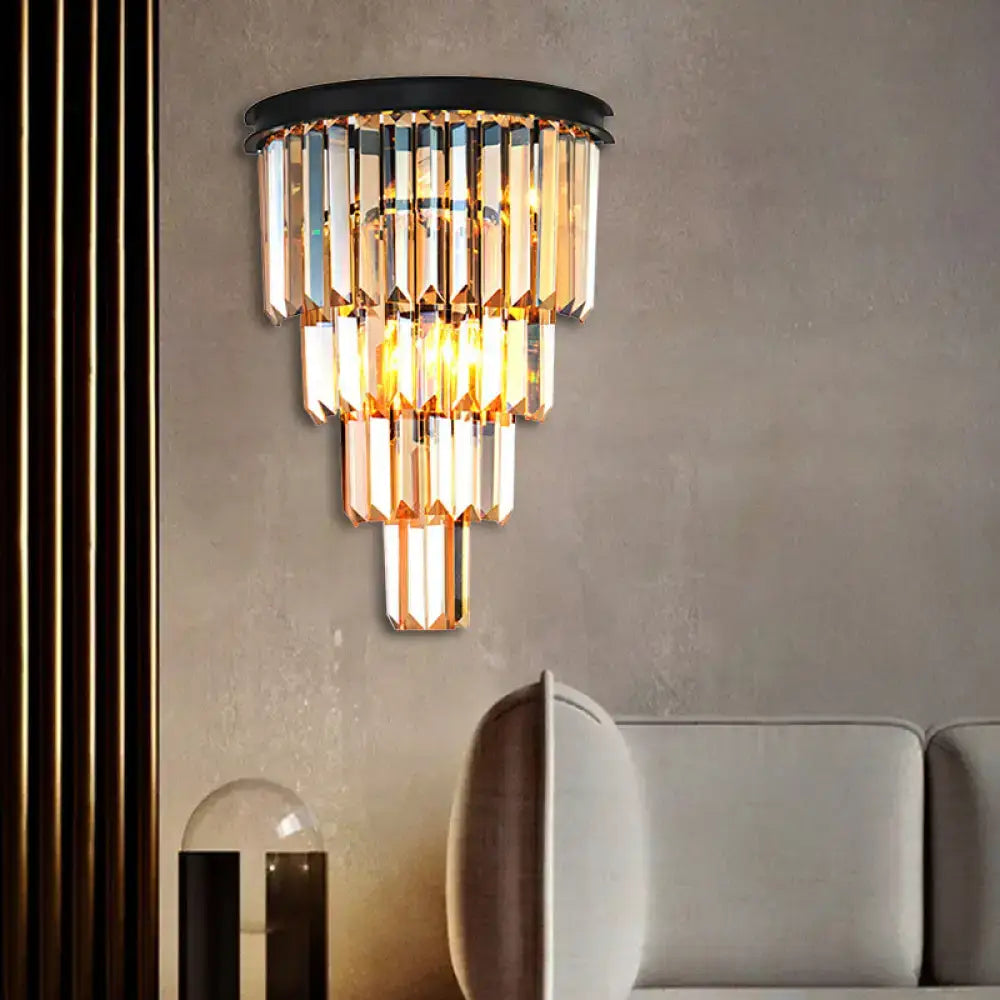 Modern wall mounted fixture with cascading clear amber crystal prisms in black metal frame for living room use