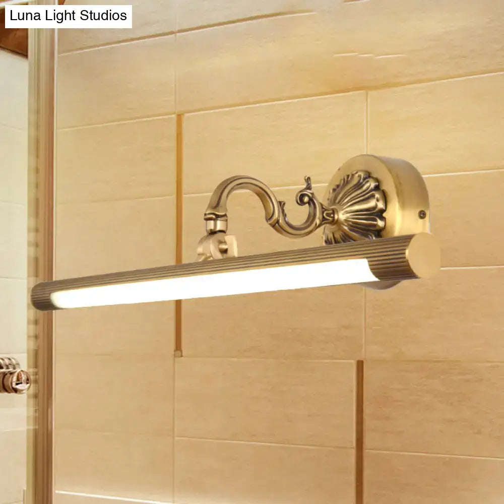 Modern antique brass integrated led wall light with brass finish ribbed cylindrical lamp and ornate scrollwork arm for vanity