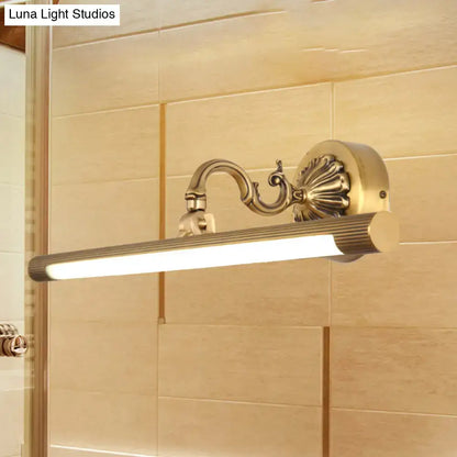 Modern antique brass integrated led wall light with brass finish ribbed cylindrical lamp and ornate scrollwork arm for vanity