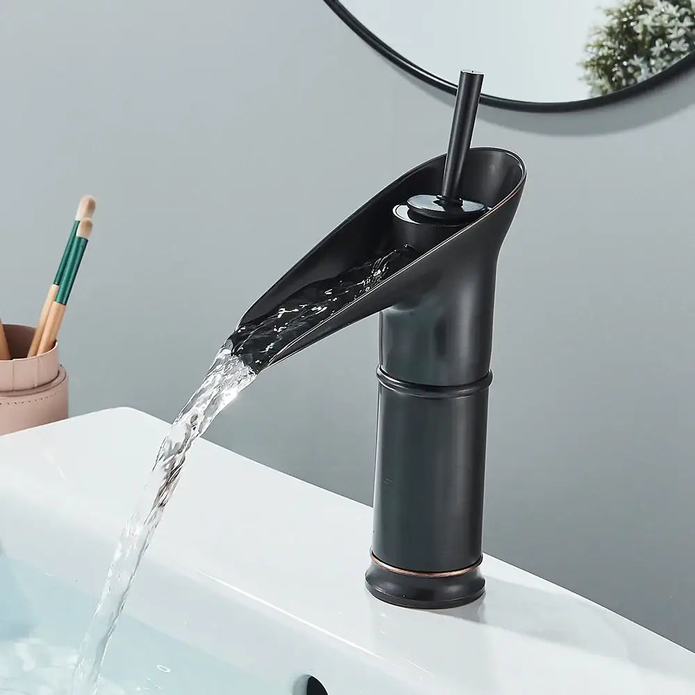 Modern antique brass and matte black waterfall faucet with cold water feature and subtle antique brass finish accents