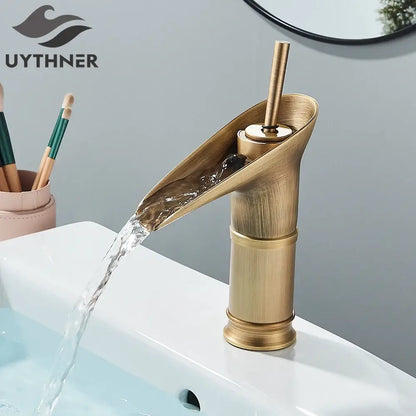 Modern antique brass waterfall faucet with brass finish and matte black accents for bathroom sink use