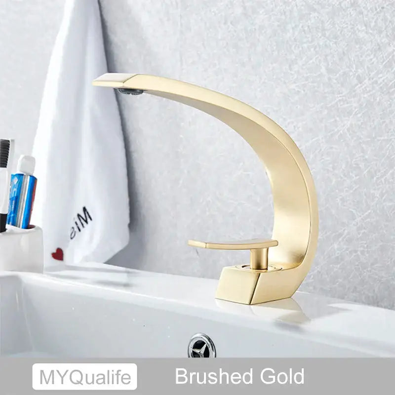 Modern arched brushed gold basin faucet with a sleek curved design for elegant bathroom mixer use