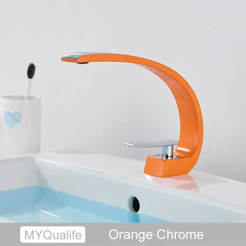 Modern arched brushed gold basin faucet with an orange chrome curved design and polished metallic accents for bathroom use
