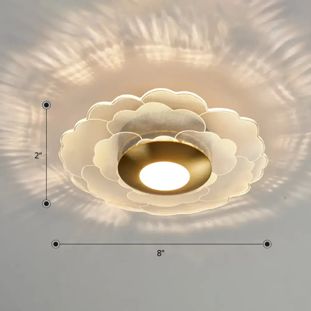 Modern art deco white and gold flower wall sconce light with layered translucent petals and warm gold center