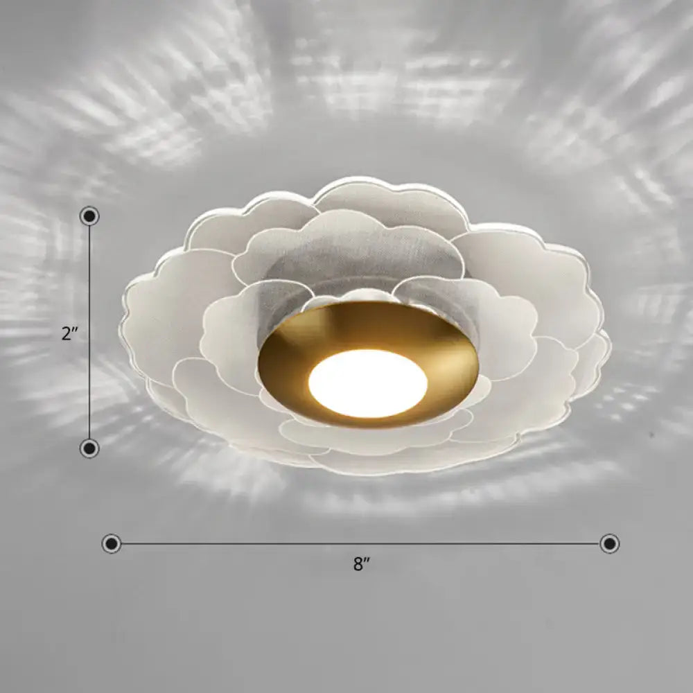 Modern art deco white and gold flower wall sconce light with layered petal design and central gold bulb for living room