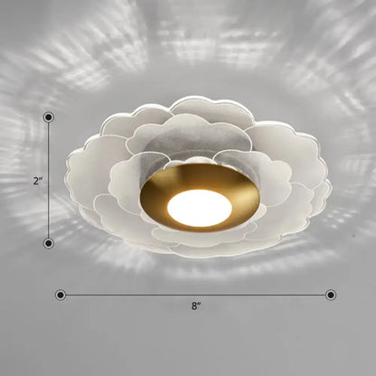 Modern art deco white and gold flower wall sconce light with layered petal design and central gold bulb for living room