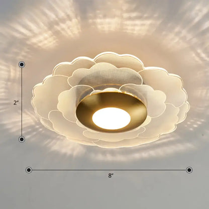 Modern art deco wall sconce light with layered white translucent flower design and gold toned metal for living room