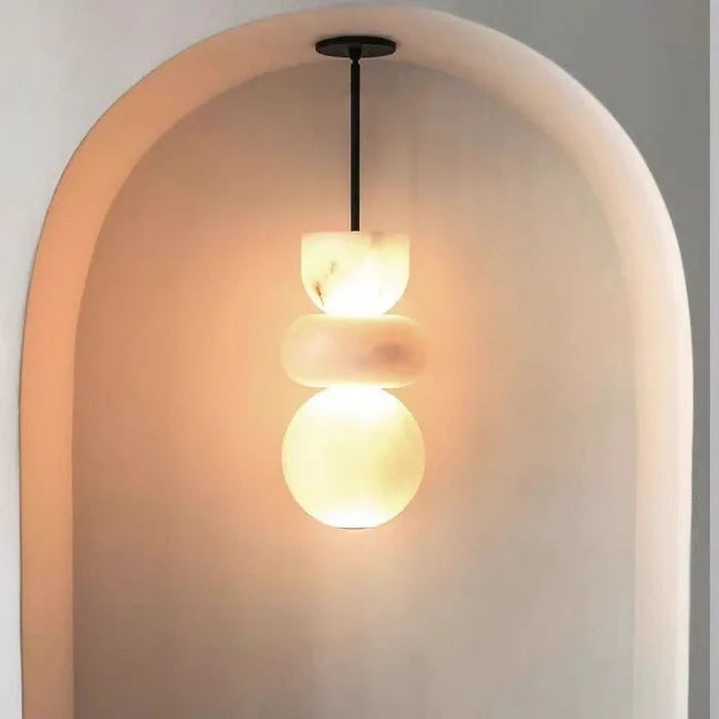A modern pendant light with three stacked alabaster indoor ceiling shades made of spanish marble for kitchen decor