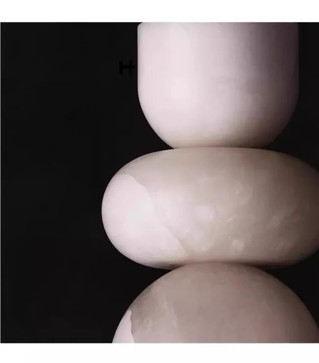 Three stacked smooth off-white ceramic orbs with subtle marbled veining in a spanish marble alabaster indoor ceiling chandelier