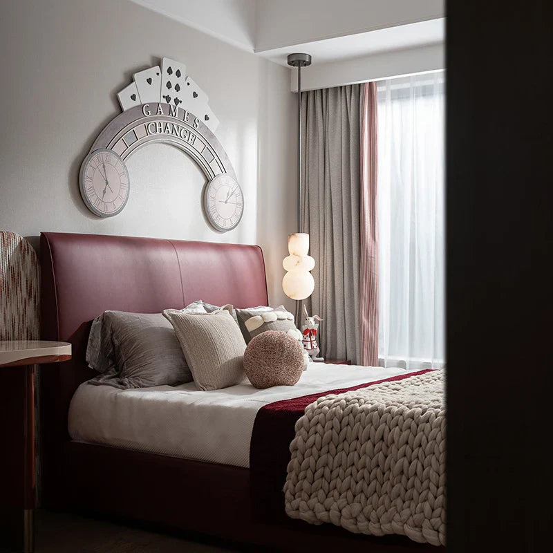 Burgundy leather headboard with smooth padded surface and subtle stitching complements alabaster indoor ceiling chandelier decor