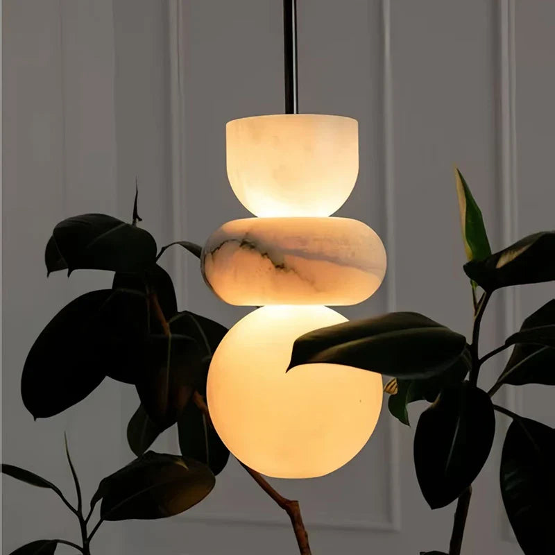 A modern pendant light with three warm-toned spanish marble orbs for alabaster indoor ceiling chandelier decor