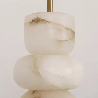 Stacked white onyx stones with brown veining mounted on brass stem in modern alabaster indoor ceiling chandelier with spanish marble design