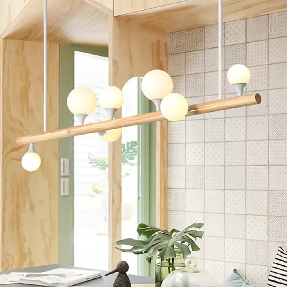 Modern asian wood hanging ceiling light with natural wood bar and five frosted glass globe bulbs for dining room