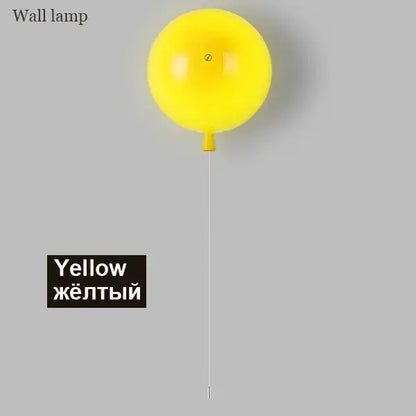 Modern balloon wall light in bright yellow with a glossy finish and small orange stem for bedroom use