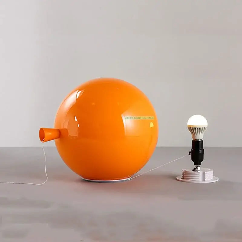 Modern balloon wall light featuring a vibrant orange glossy spherical lamp with a small nozzle side protrusion