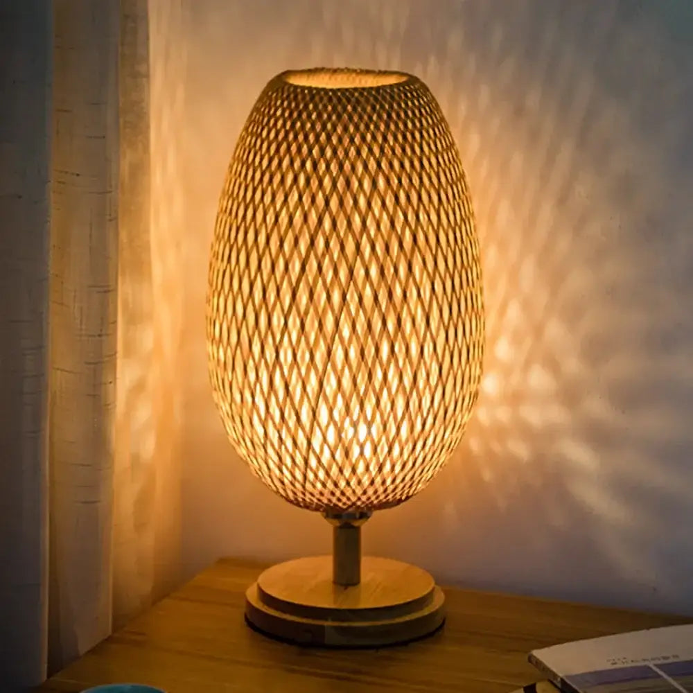 Warm-toned modern bamboo weave table lamp with egg-shaped woven shade and wooden base for bedroom lighting