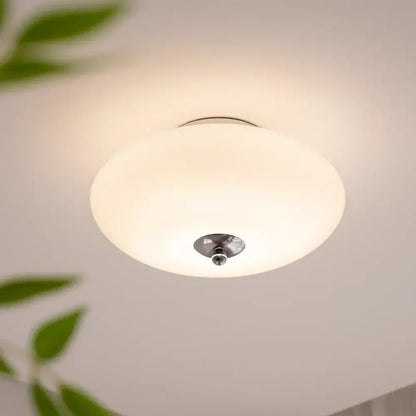 Modern bauhaus cream white ceiling lamp with a frosted cream white glass shade and polished brass light accents for bedroom
