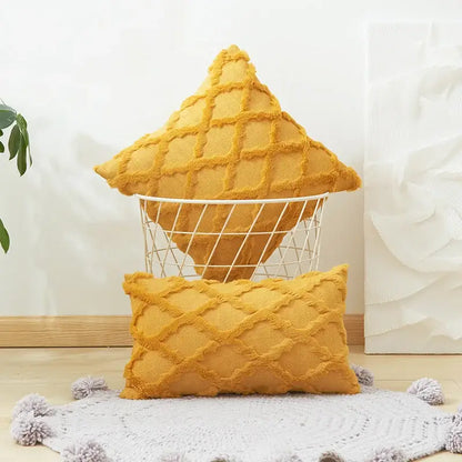 A mustard yellow solid embroidery cushion cover with diamond solid embroidery and frayed edges in a wire basket