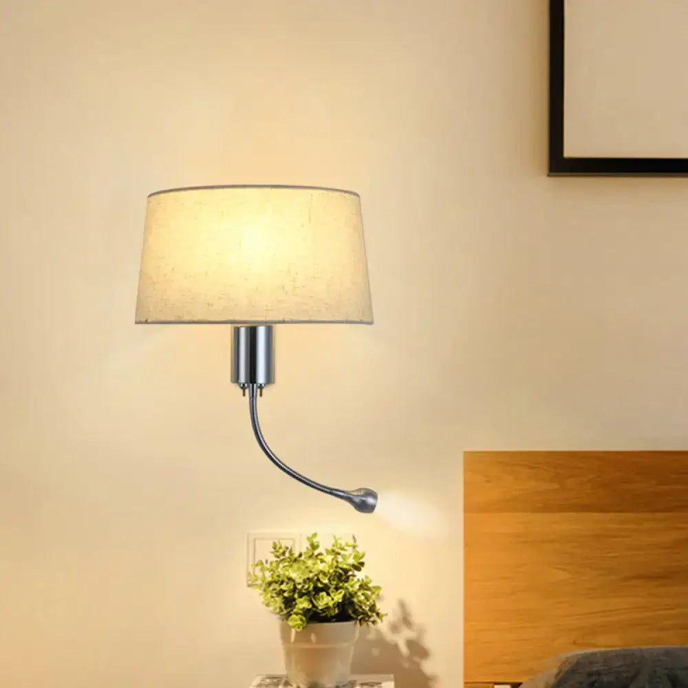 A sleek modern beige fabric flush wall sconce with curved metallic arm for bedroom reading light