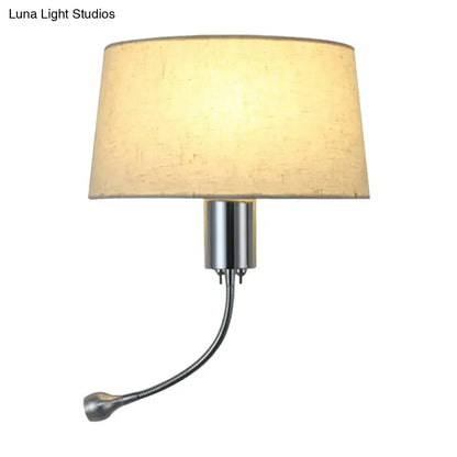 A sleek modern beige fabric flush wall sconce with chrome metal components for bedroom reading light use