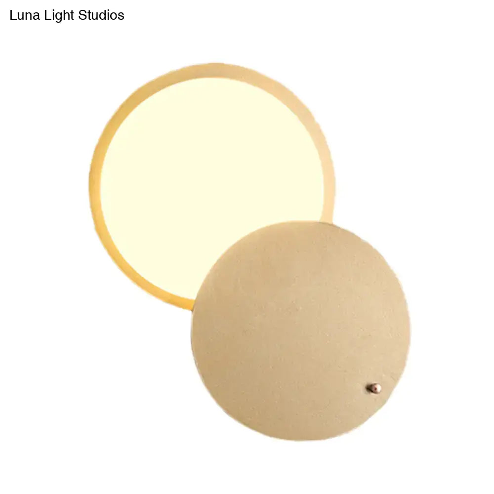 Modern beige and gold metal wall lamp with circular rotatable design and warm diffused glow for bedroom sconce