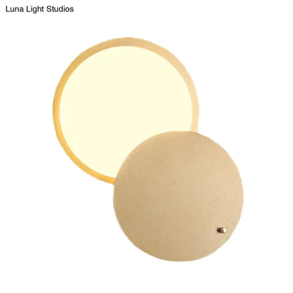 Modern beige and gold metal wall lamp with circular rotatable design and warm diffused glow for bedroom sconce