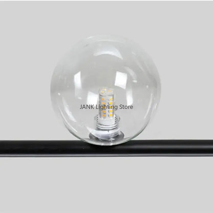 Modern black 7 light glass shade pendant light featuring a clear glass globe with multiple yellowish leds mounted on a black rod