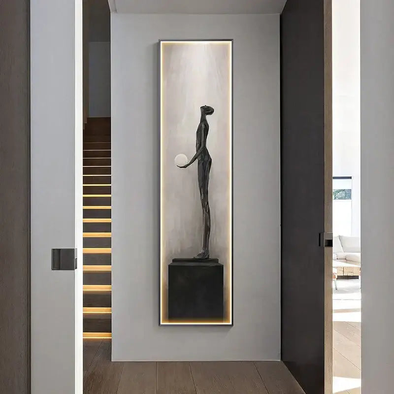 A sleek dark bronze abstract art led wall lamp with a slender figure and sphere on black pedestal for living room decorbites decor