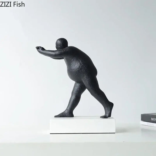 Modern black abstract resin sculpture of a stylized overweight figure in mid-stride on a white base for home decor