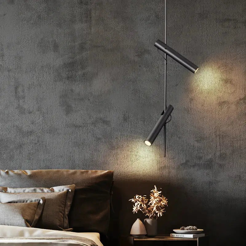 Modern black adjustable led pendant chandelier with cylindrical pendant chandelier lights hanging against gray wall