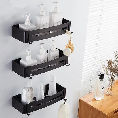 Modern black aluminum bathroom corner shelf with three tiers holding white pump bottles and hooks for bath accessories